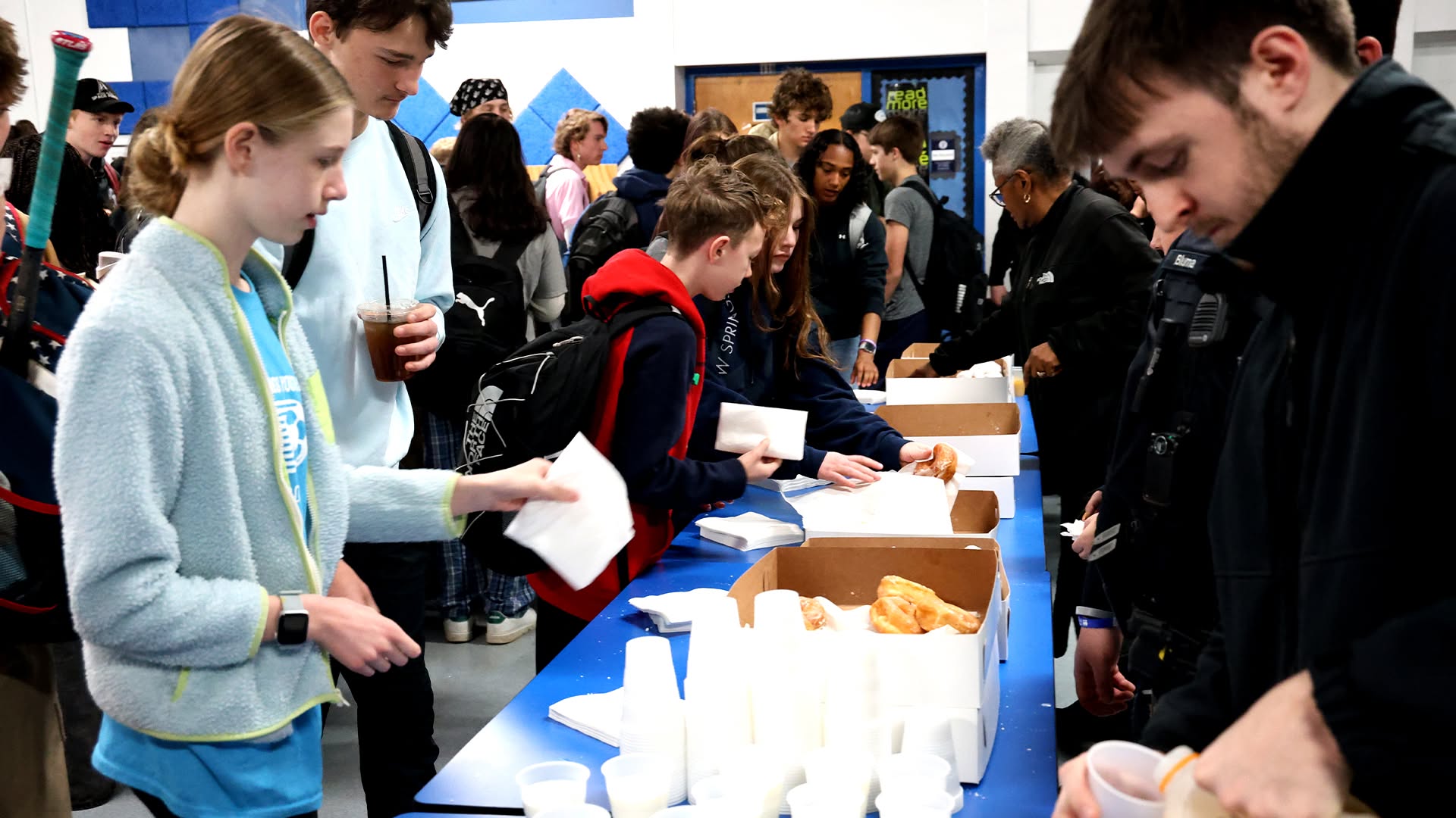 high school students and police officers with donuts
