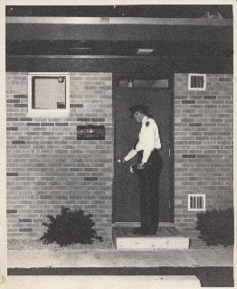 Officer with flashlight checking business